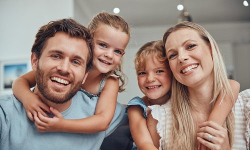 Family, happy portrait and relax together in home for quality time, relationship bonding and support in family home. Love, care and children hugging parents for happiness or smile in living room.