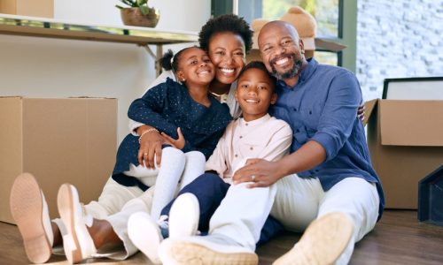 Moving, portrait and happy black family in home with boxes and hug in living room together. New house, property and smile for investment in real estate, growth and parents embrace children on floor.