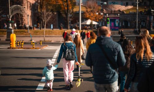 Lots of people crossing the street at the traffic lights. Populated city concept